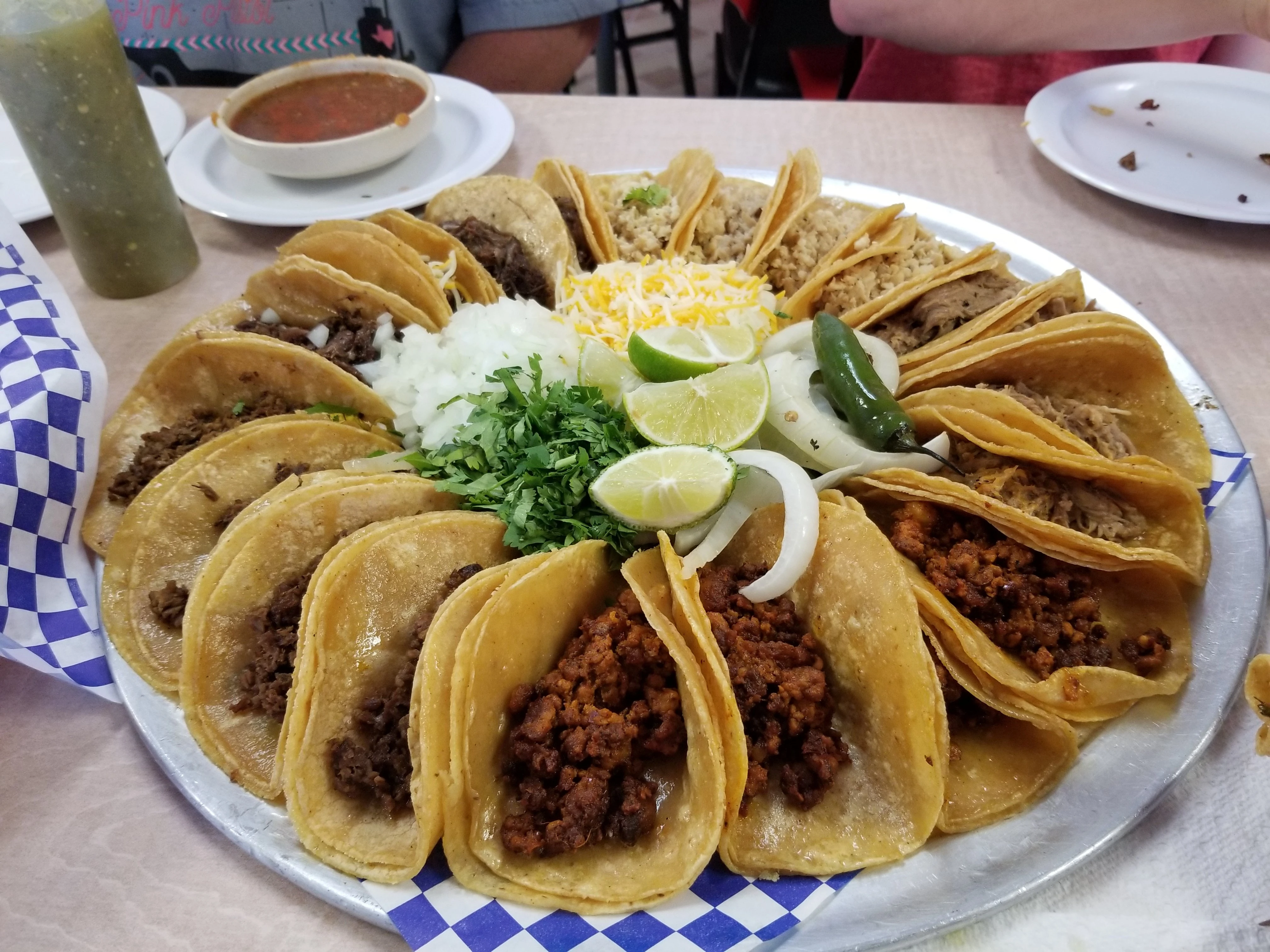 A full platter of TACOS with lime and salsa